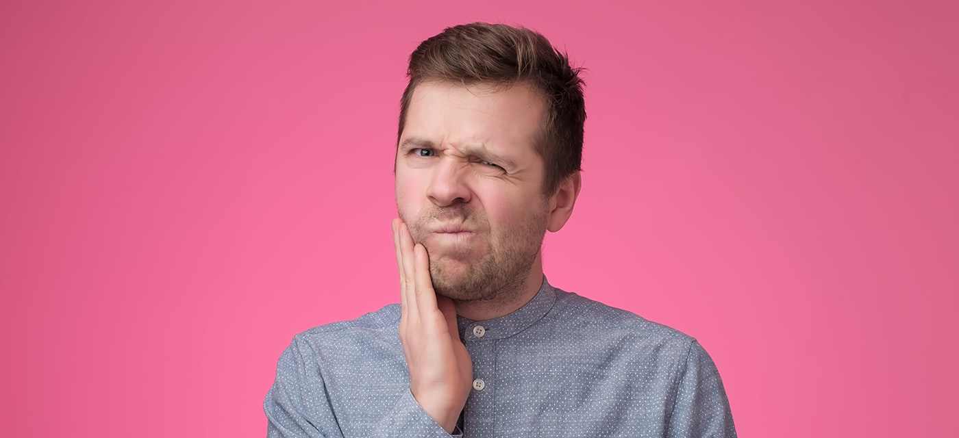 hombre con dolor de diente por caries interdental