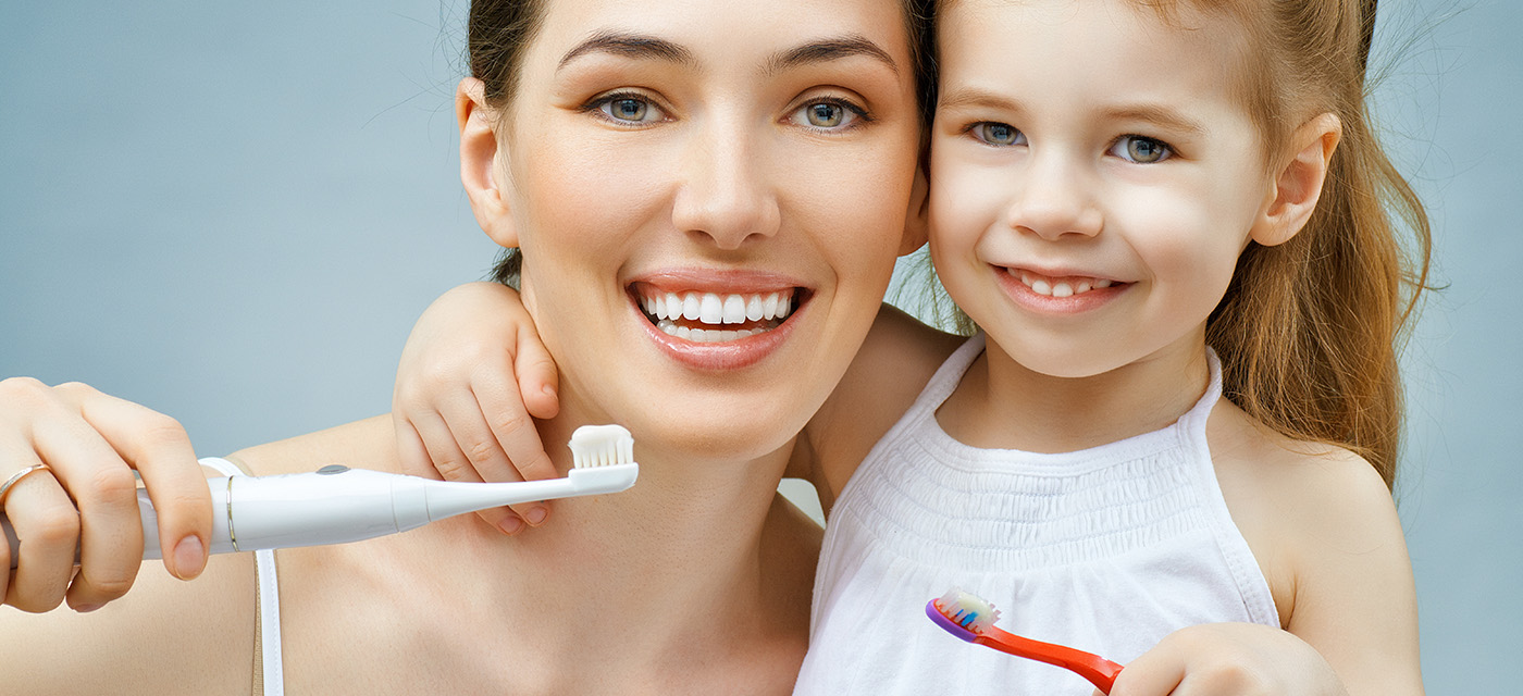 mamá e hija lavándose sus dientes