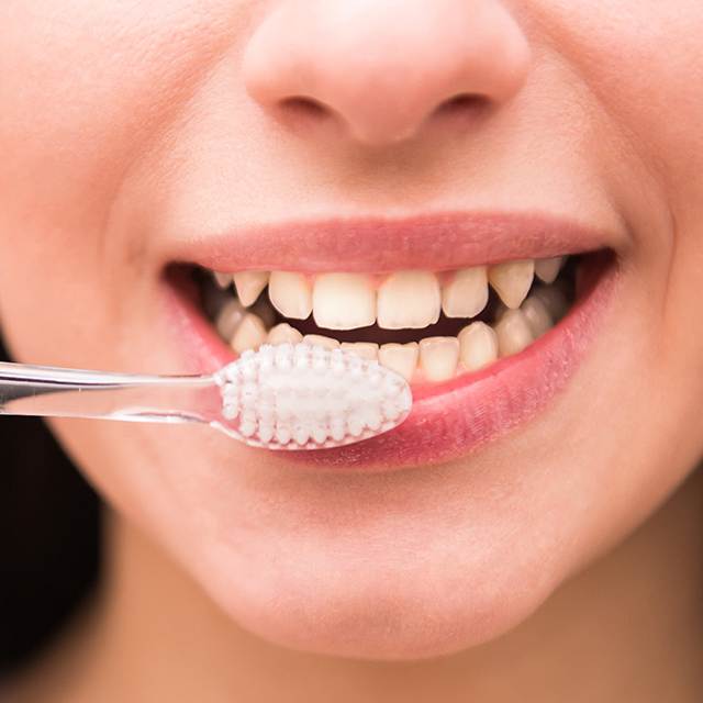 mujer se cepilla de dientes