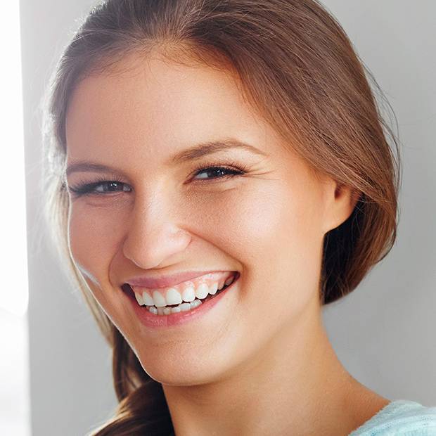 Mujer sonríe después de recuperarse de Halitosis