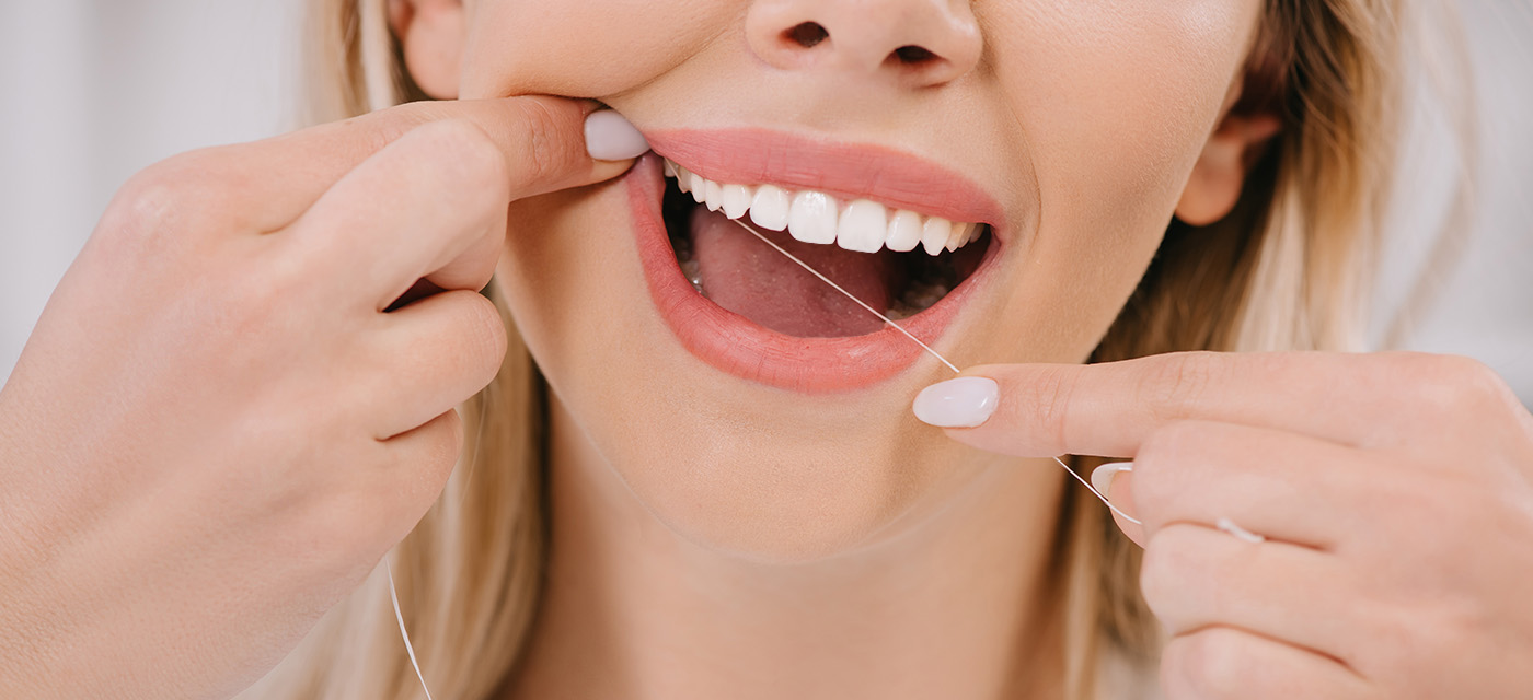 mujer usa hilo dental