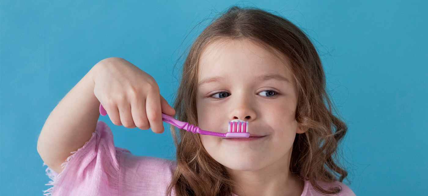 niña con cepillo de dientes