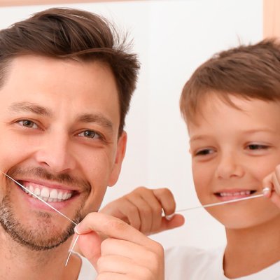 Padre e Hijo usando hilo dental