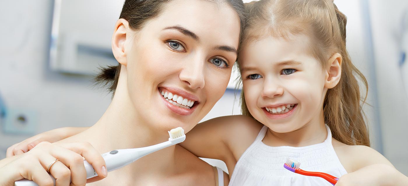 Mamá e hija con cepillo de dientes