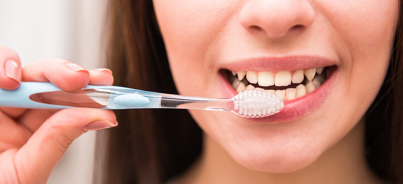 mujer se cepilla de dientes