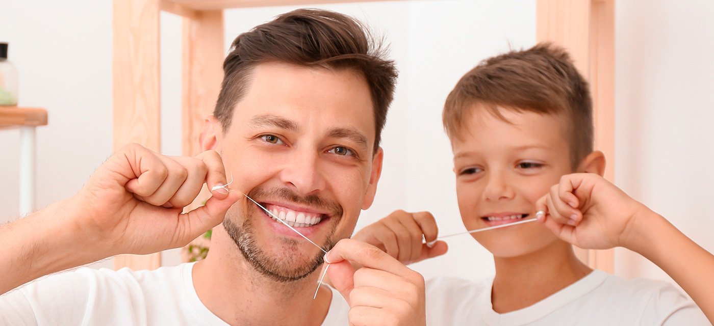 Padre e Hijo usando hilo dental