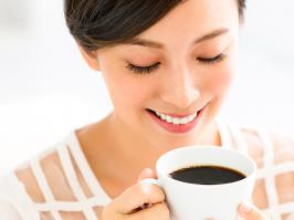 Mujer sonriendo mientras bebe una taza de café en el día internacional del café