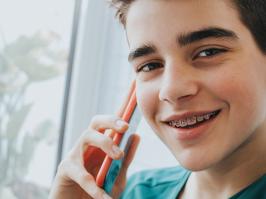 Chico joven sonriendo con ortodoncia 