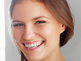 Mujer sonríe después de recuperarse de Halitosis