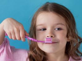 niña con cepillo de dientes